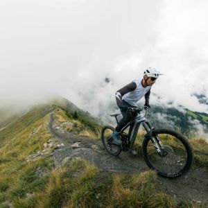 A mountain biker ascends a mountain ridge on a Giant Reign Advanced E+.
