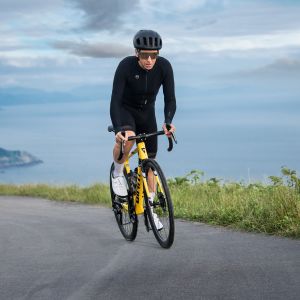 Action shot of a cyclist climbing out of the saddle up a sea-side climb on the Giant TCR Advanced SL Legends Edition.