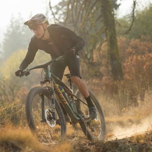 A mountain biker rips down a trail in fall on a Giant Anthem X Advanced SL.