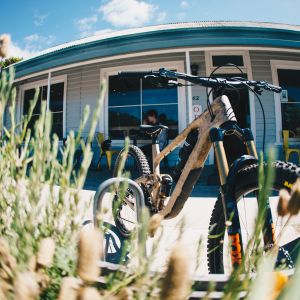 mountain bike parked in stand in front of cafe