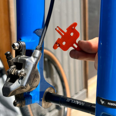 Place a pad spacer (or piece of cardboard) between the brake pads.