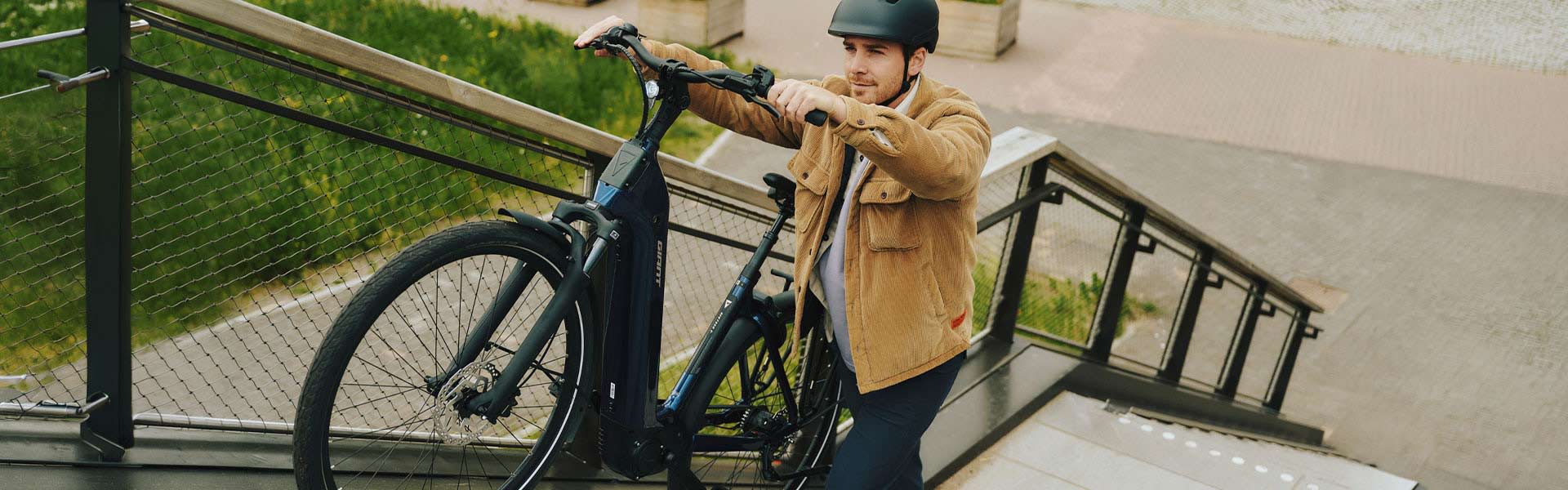 Person pushing e-bike up stairs.