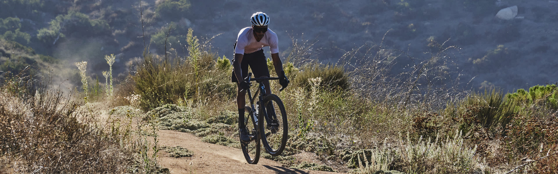 man riding a Revolt X gravel bike on gravel/dirt