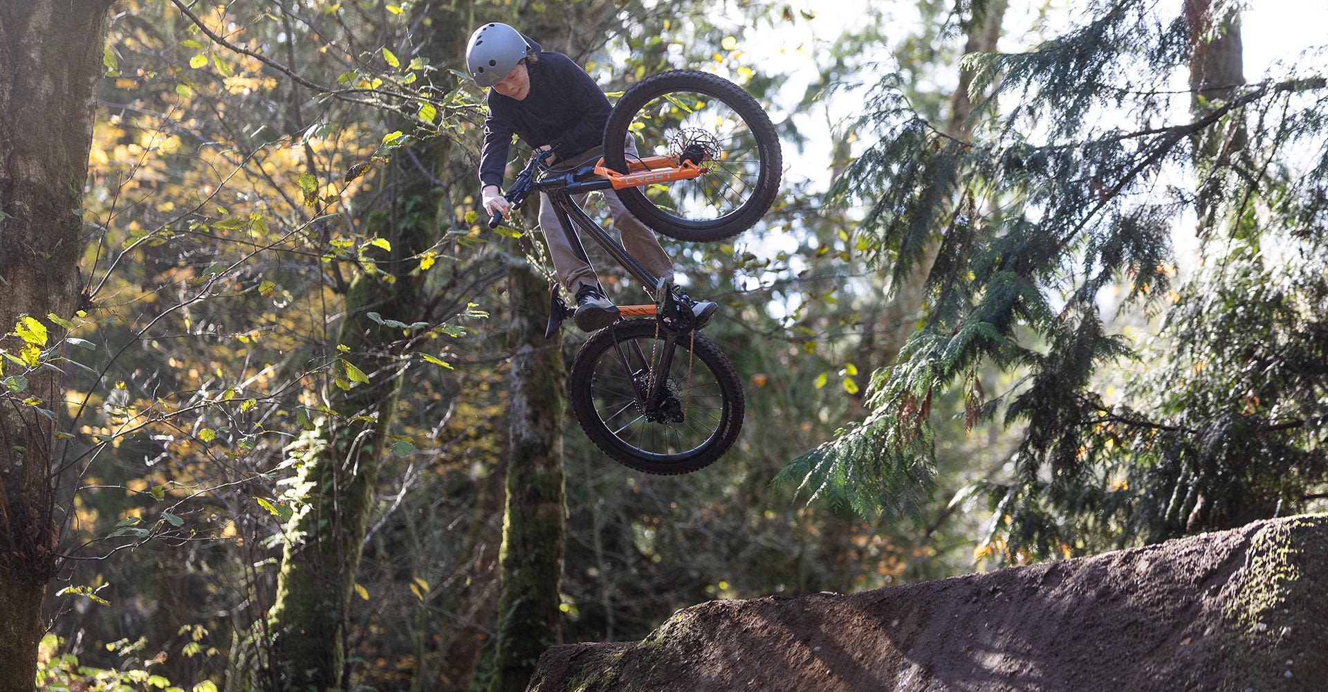 kid jumping a dirt jumper in forest