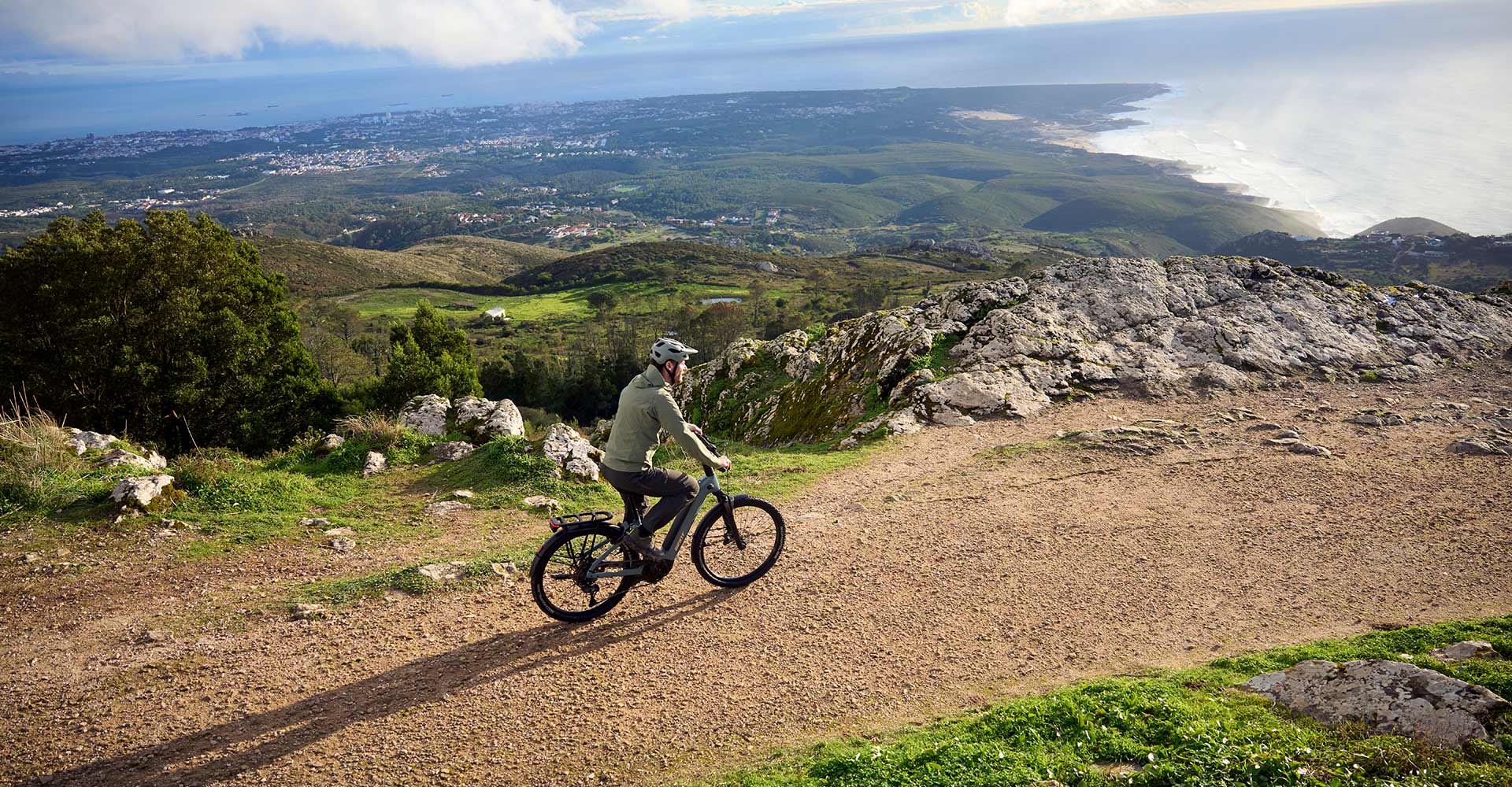 cyclist on an ebike riding dirt road during sunset