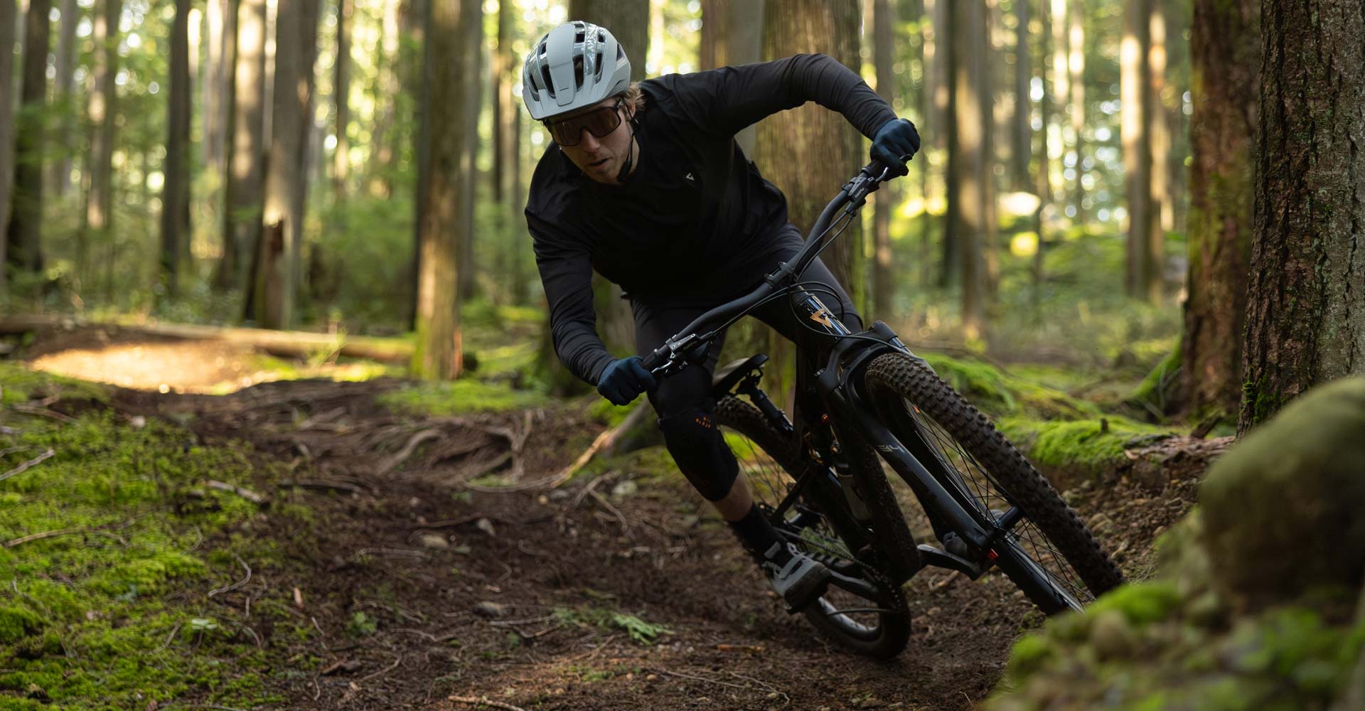 Mountain biker cornerning a trail bike in the forest