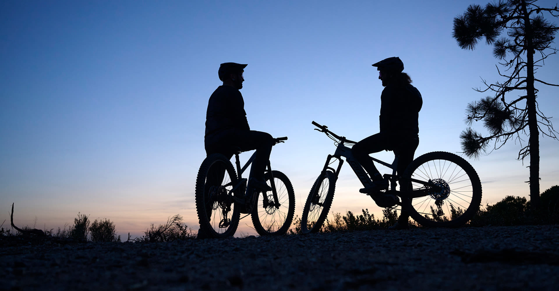 electric mountain bikers resting during sunset
