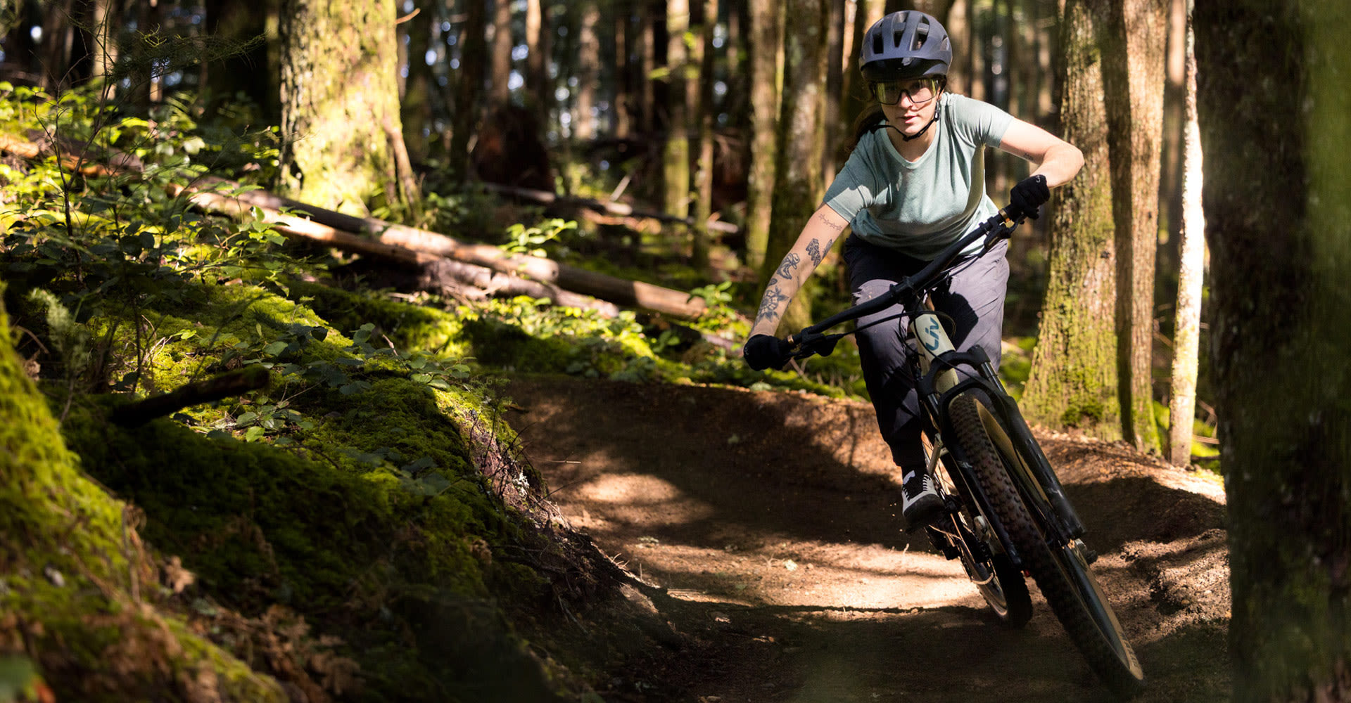 Woman riding Liv Embolden around a dirt corner.