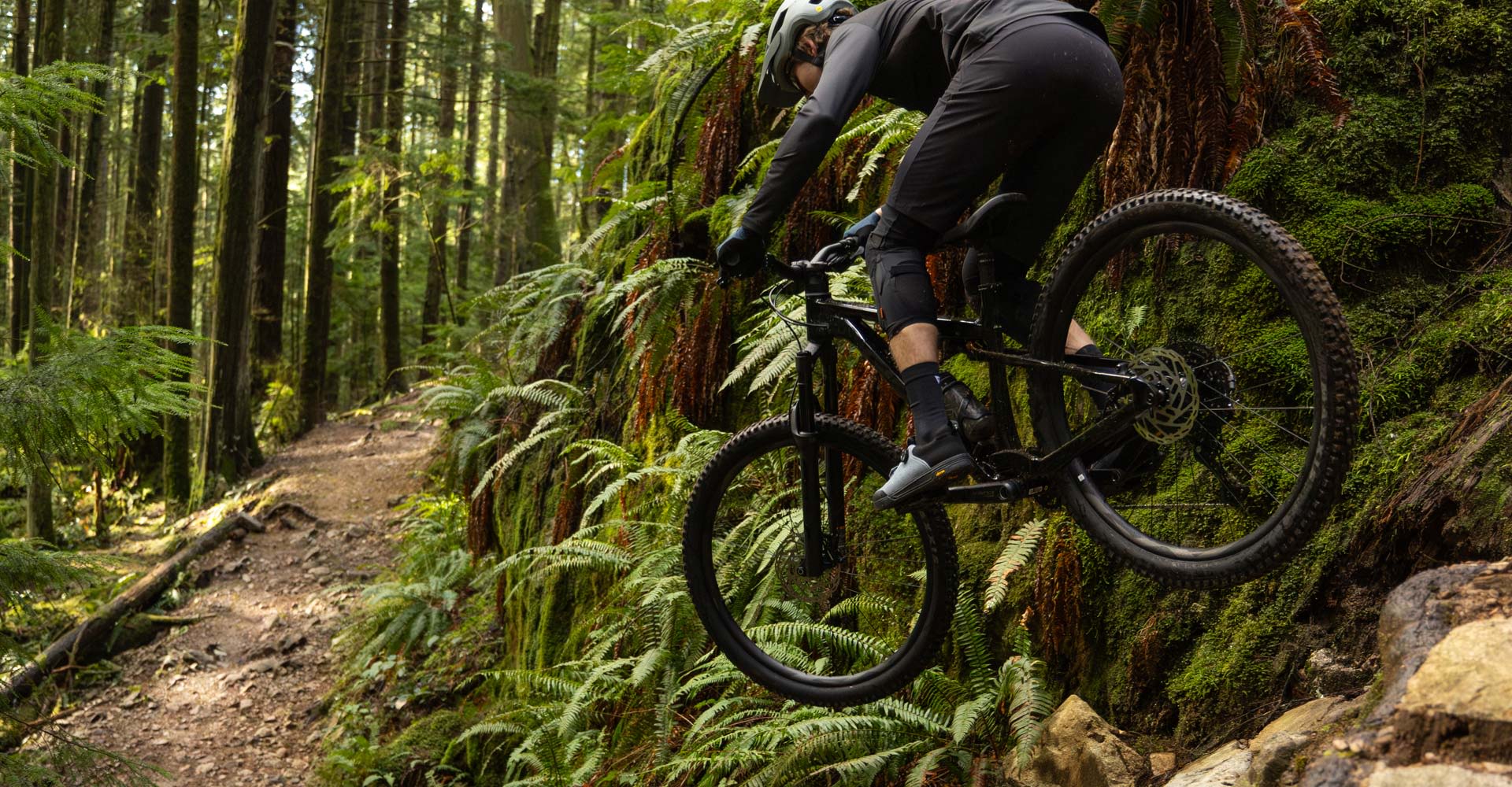 rider on stance descending rocky section of trail