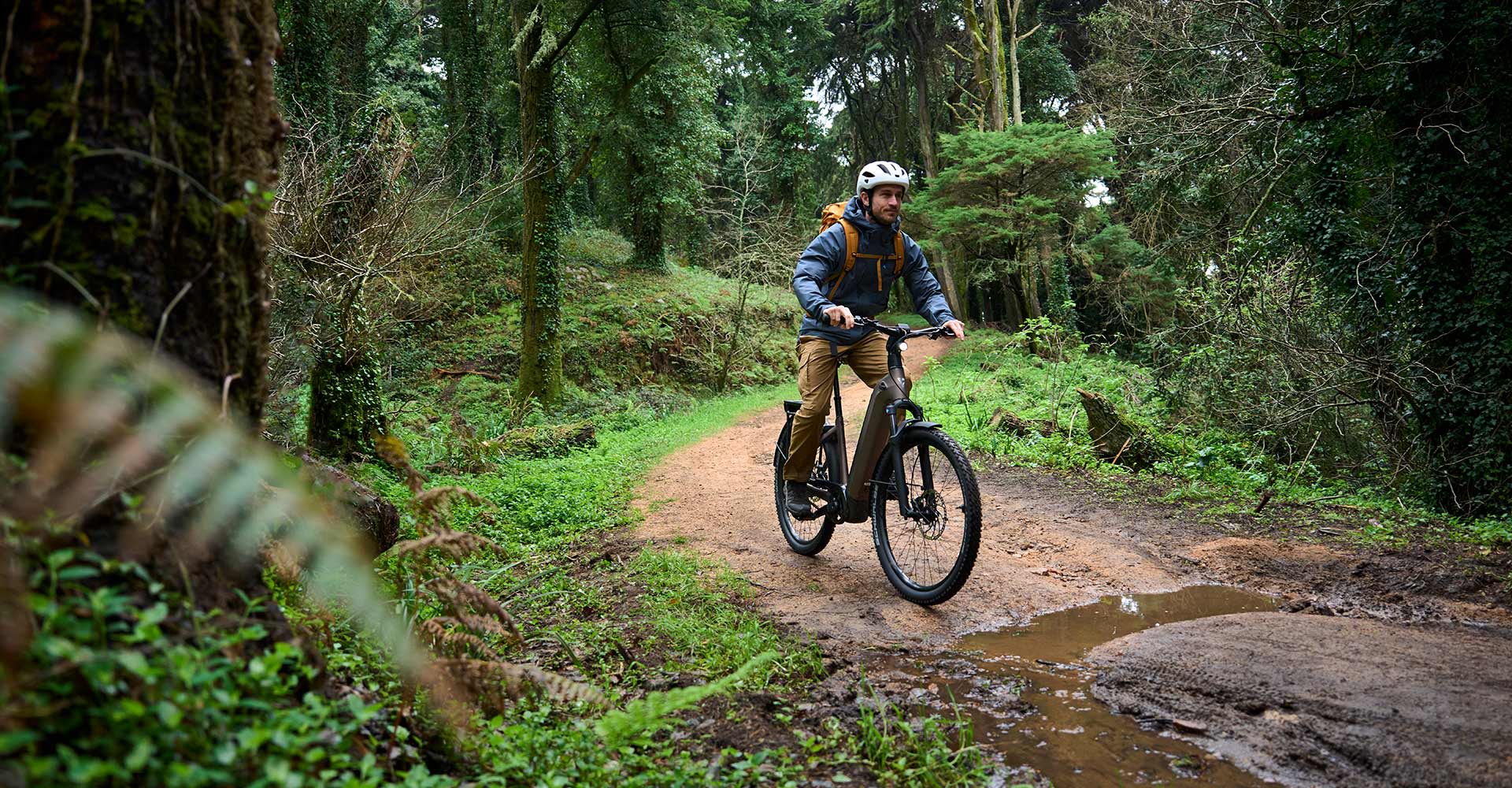 ebiker riding on a dirt road after rain