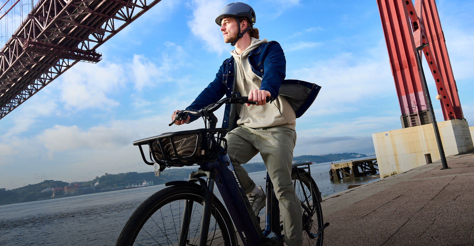 cyclist leaning against wall by electric bike