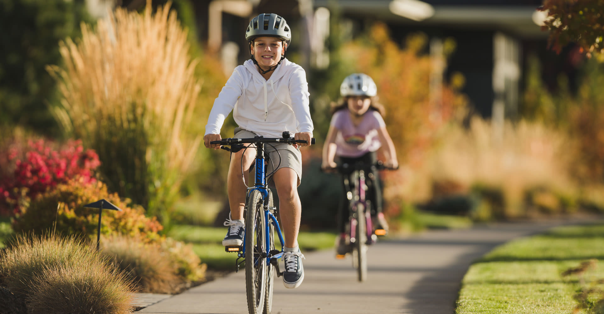 boy riding bicycle on sidewalk