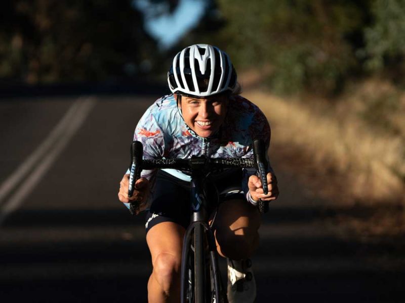 Peta Mullens smiling in aero position on a road bike