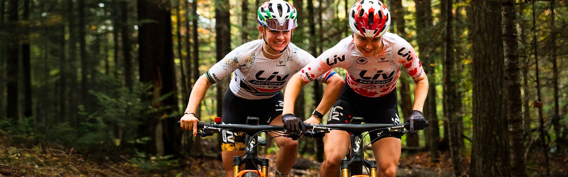 two women mountain bikers racing in forest