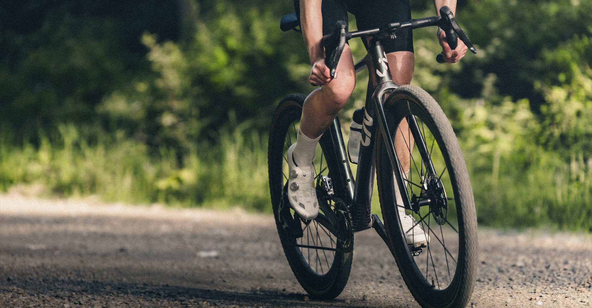 woman riding Devote Advanced SL on gravel while sun sets