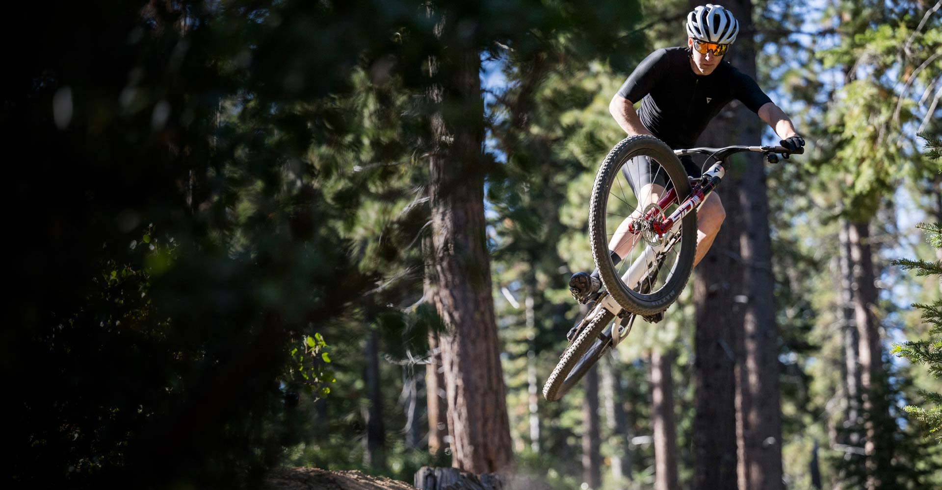 mountain biker getting some air in forest