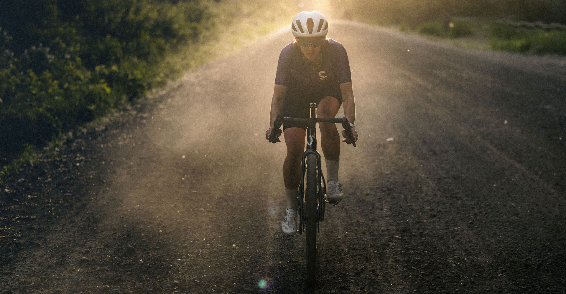 Woman riding Liv Devote Advanced SL on gravel road.