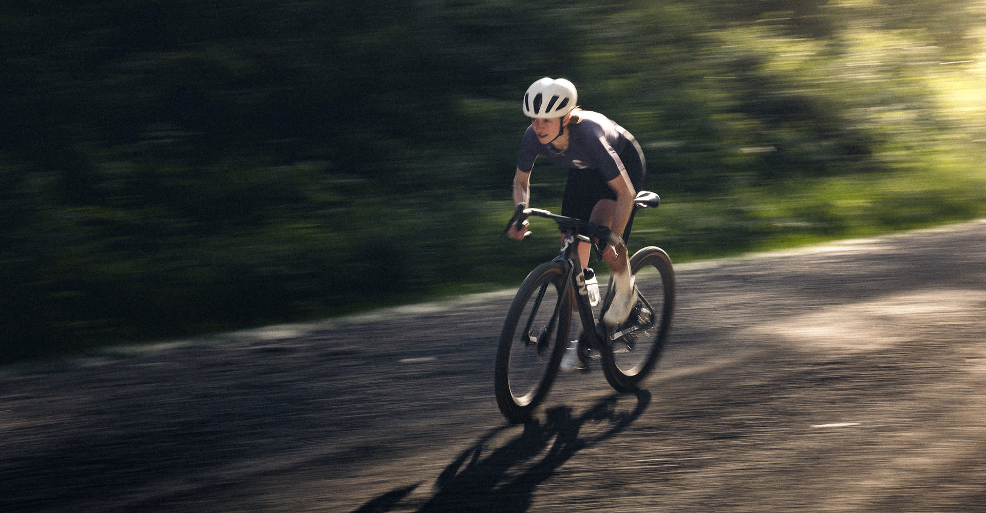 Woman riding Liv Devote Advanced SL on gravel road.