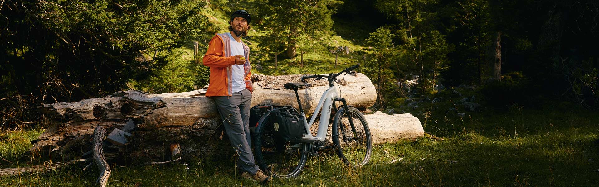 biker leanign against downed trees