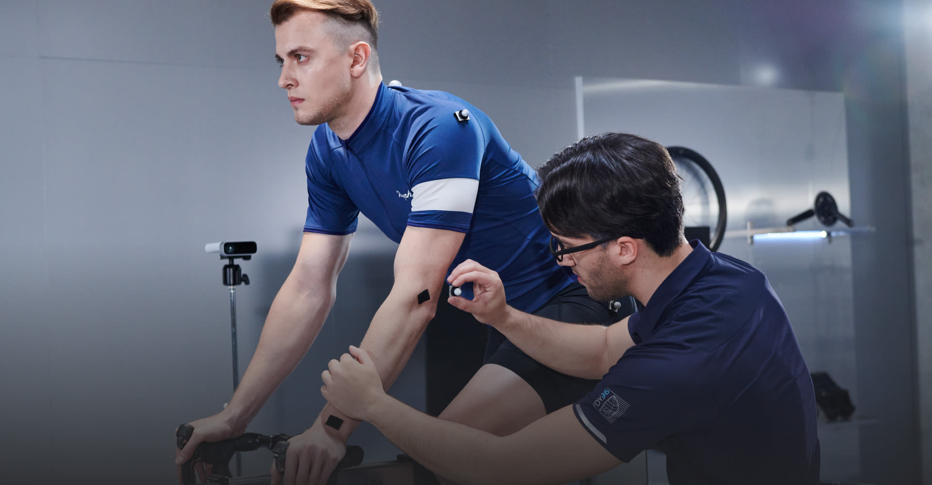 fitter putting on motion capture on cyclist