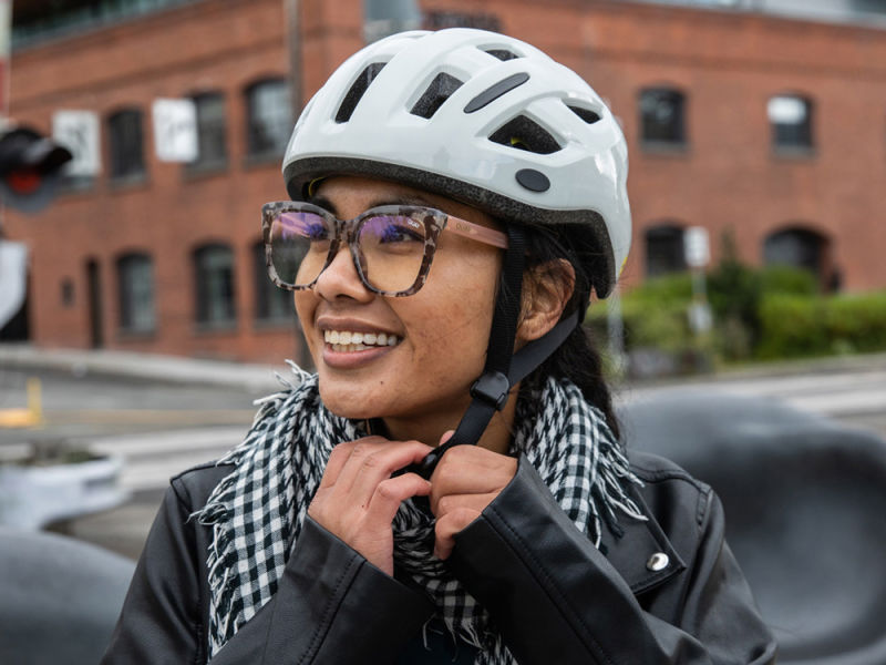 a woman putting on a bike helmet