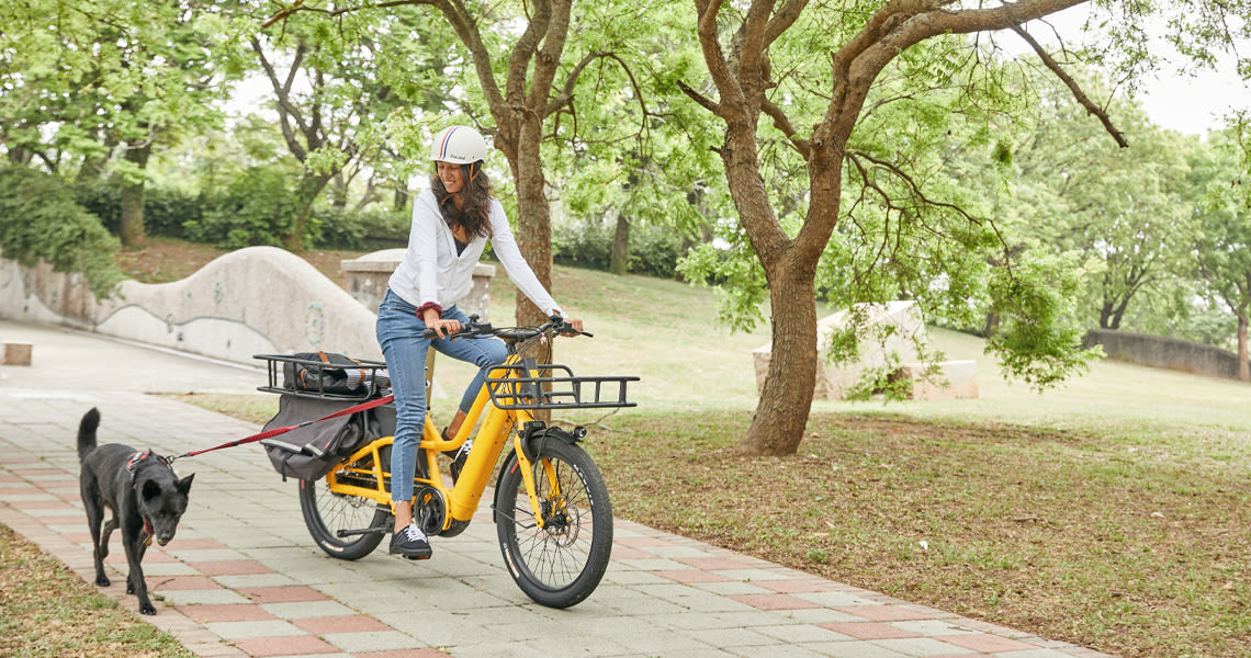 woman biking with a dog, electric bikes